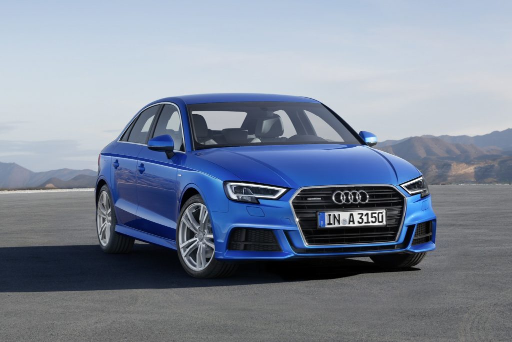 Blue Audi A3 Saloon off road with mountains in the background