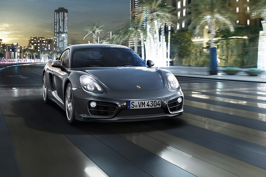 Grey Porsche Cayman Coupe driving on street