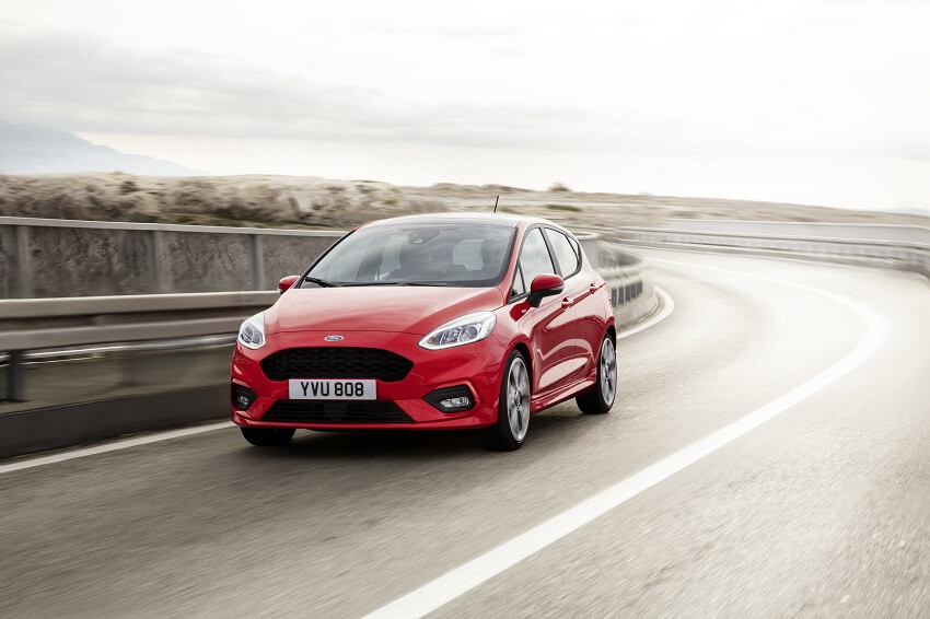 Ford Fiesta hatchback in red driving on the road