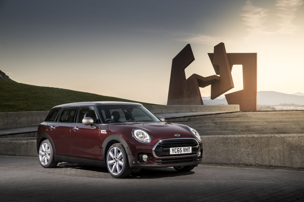 Dark red Sideview Mini clubman at sunset with sculpture in the background