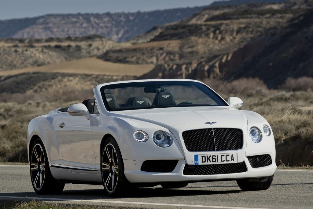 White Bentley Continental convertible on a road with grass in the background