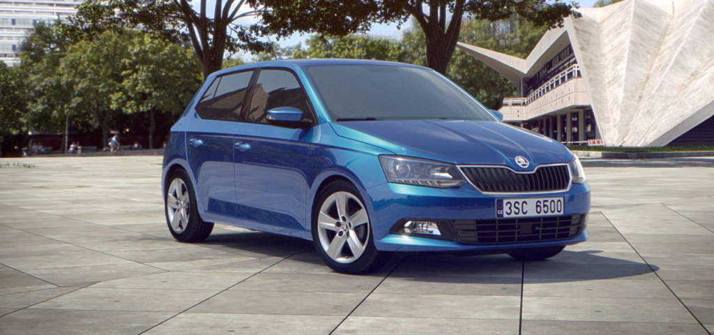 Blue Skoda Fabia with a building and trees in the background