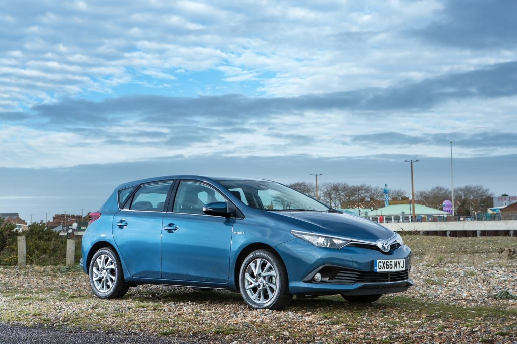 a blue Toyota Auris outside a city in beached area