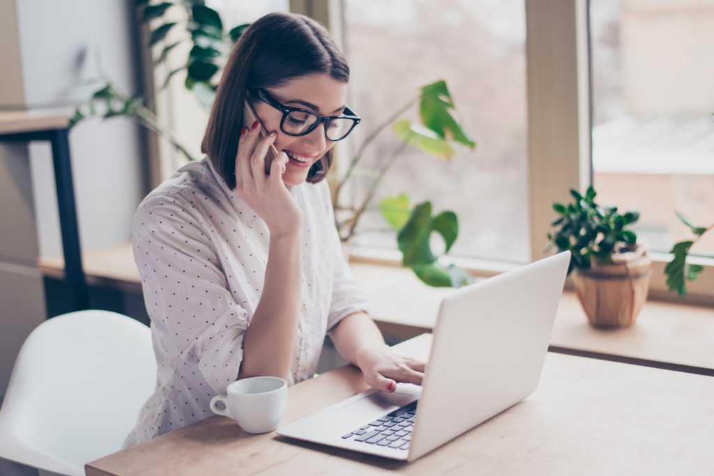 women talking on the phone whilst on a laptop - safety features to look for