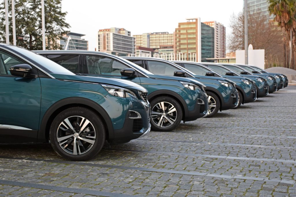 dark green coloured Peugeots lined up in a row