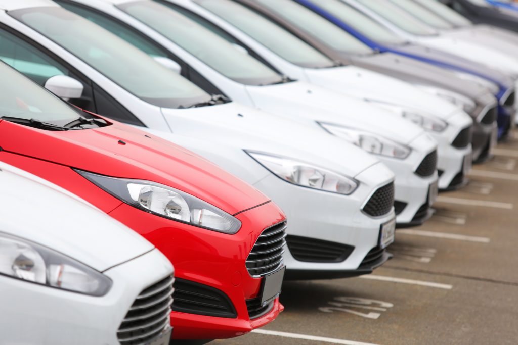 cars parked up in a line in car parking spaces with numbers