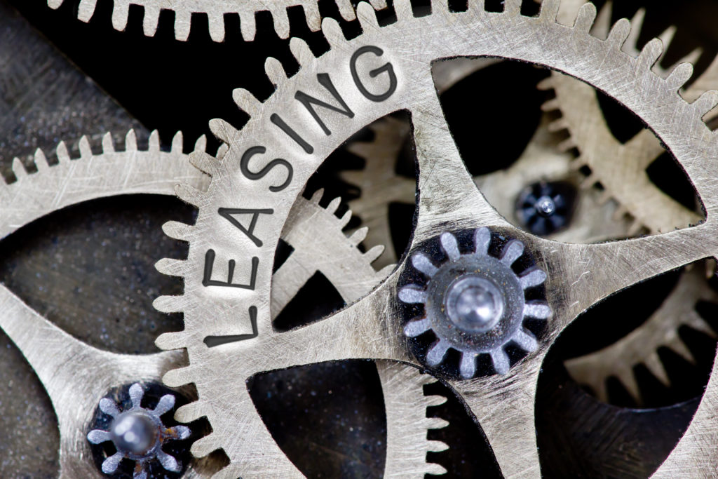 Silver metal cogs with 'leasing' written on them