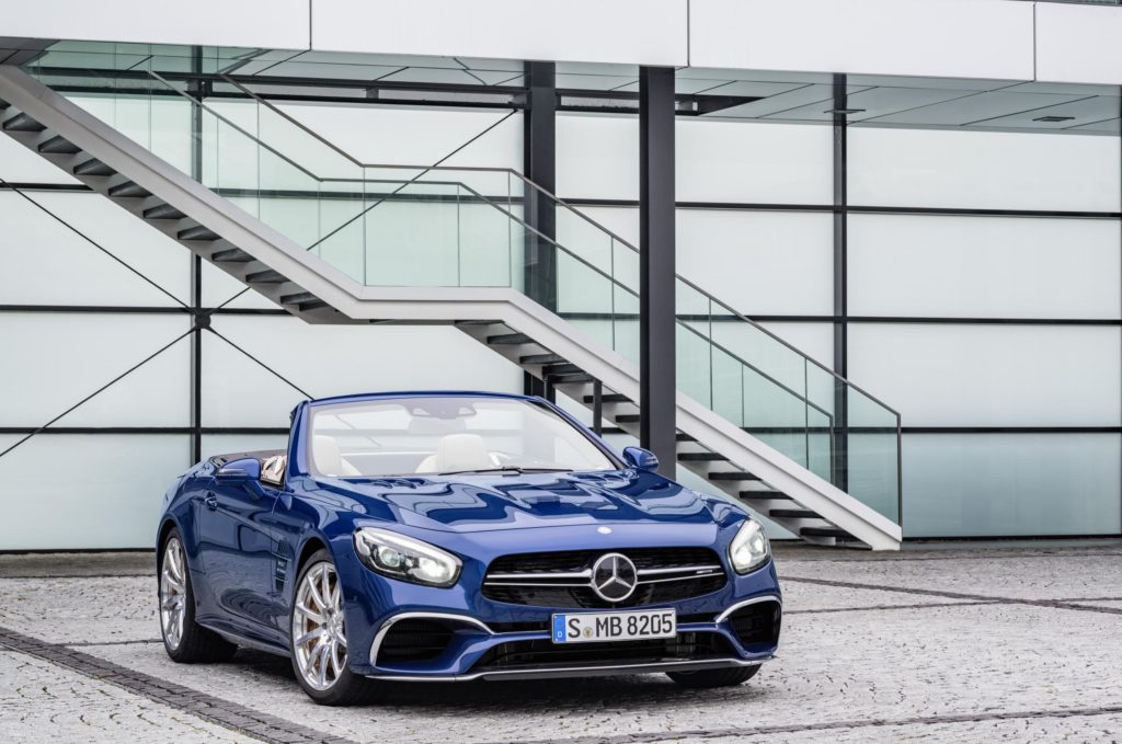 metallic blue mercedes-benz sl amg convertible parked outside a modern building with flights of stair on the side