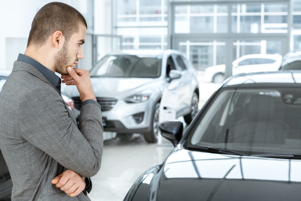 Man looking at a car thinking about getting a new vehicle.