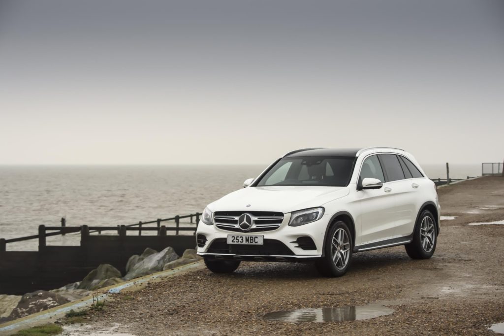 white mercedes benz glc diesel estate parked on gravel path next to a beach