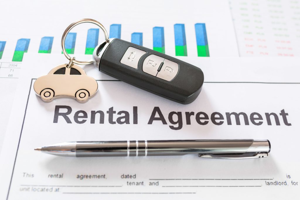 Rental Agreements papers with car keys and a pen