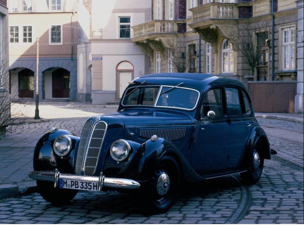 BMW 335 parked on a cobbled street with buildings behind it