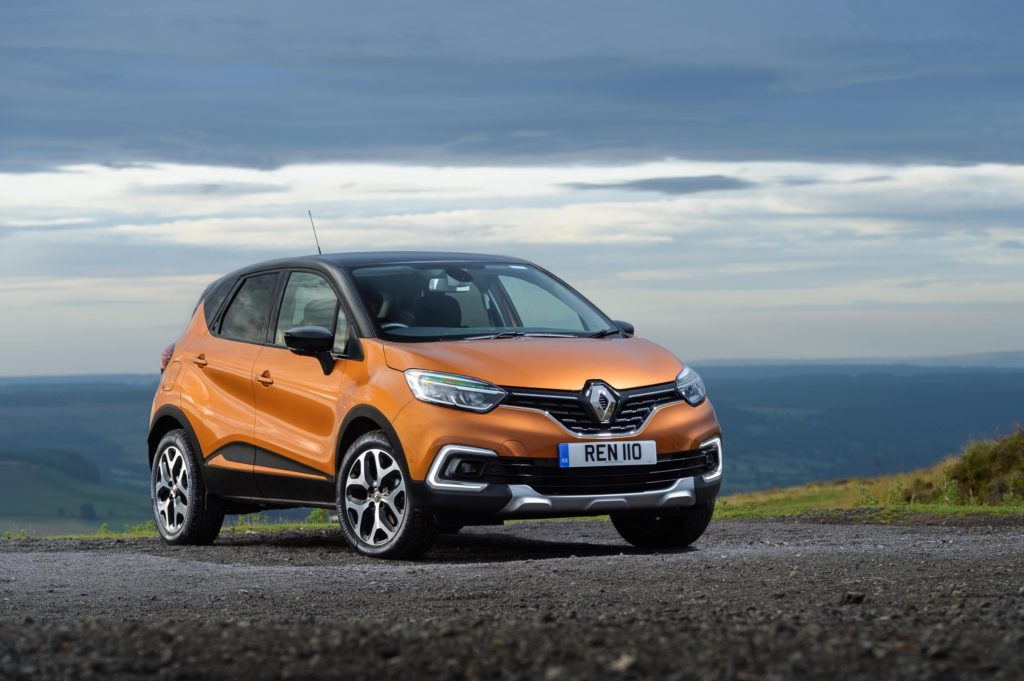 a metallic renault captur hatchback parked on dark gravel with horizon in the background