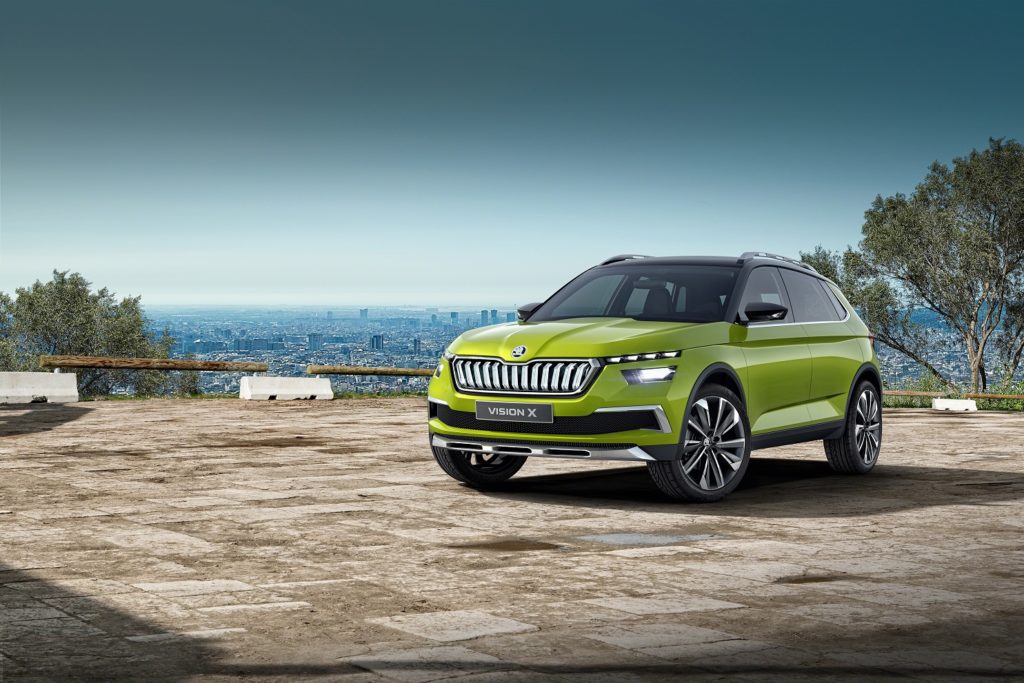 a metallic green skoda vision X parked on pavement with blue skies in the background