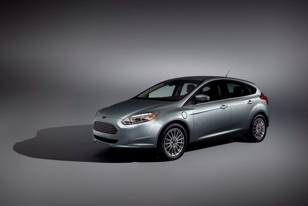 a metallic ford focus electric isolated on a grey background with its shawdow behind