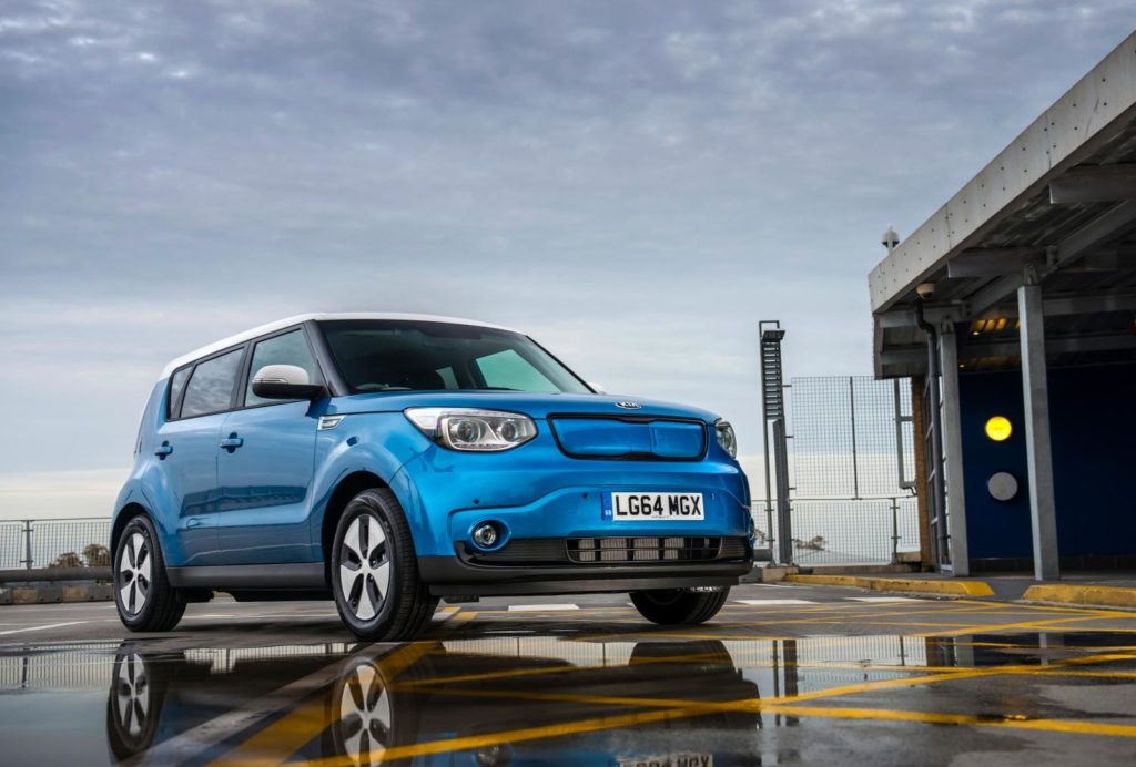 a metallic blue Kia Soul EV in the rain