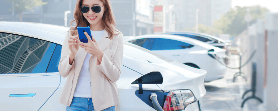 Woman smiling at EV car